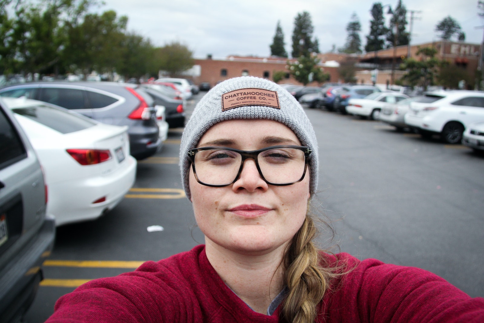 Woman Taking Photo Of Herself Near Parked Vehicles